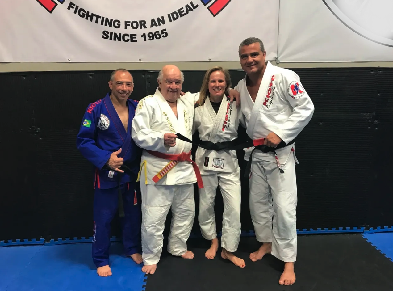 Black belt promotion under the "Fighting for an Ideal Since 1965" banner with Master Mansor